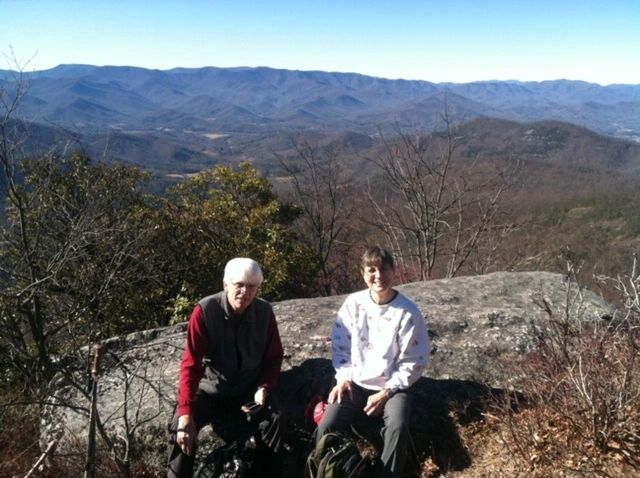Two hikers sitting rocky mountain overlook